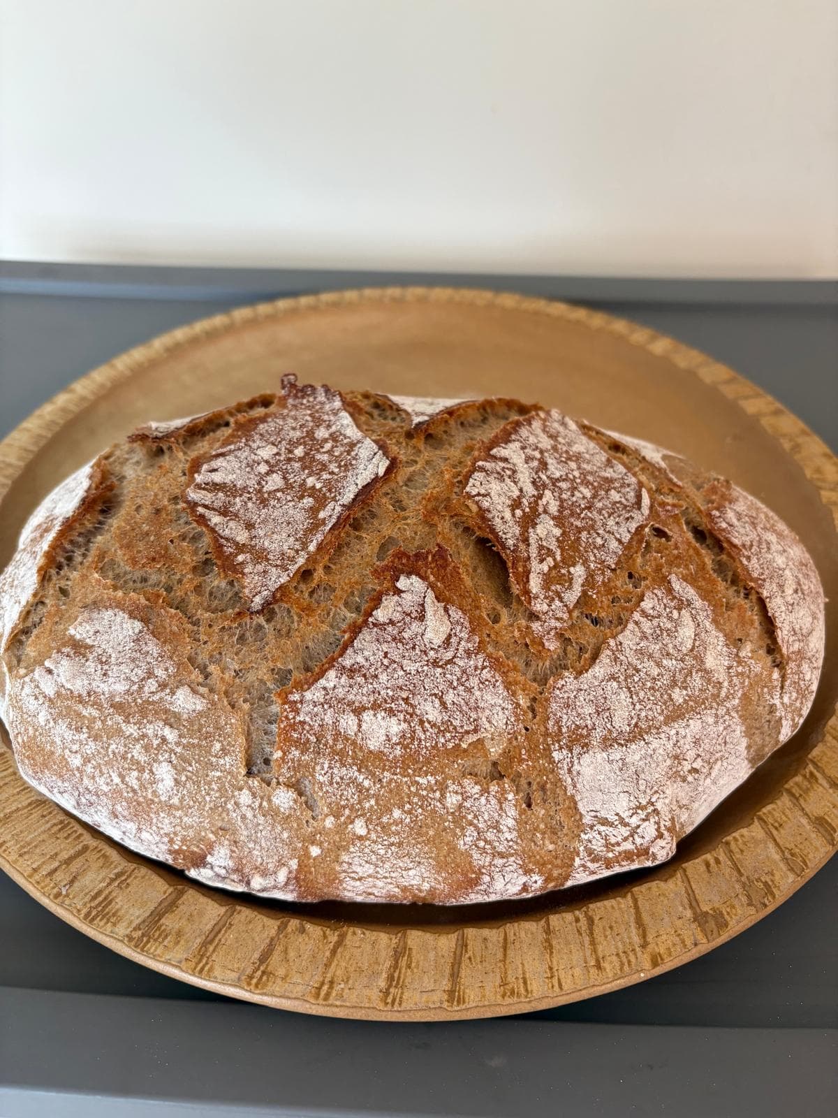 A round rye loaf on a ceramic plate